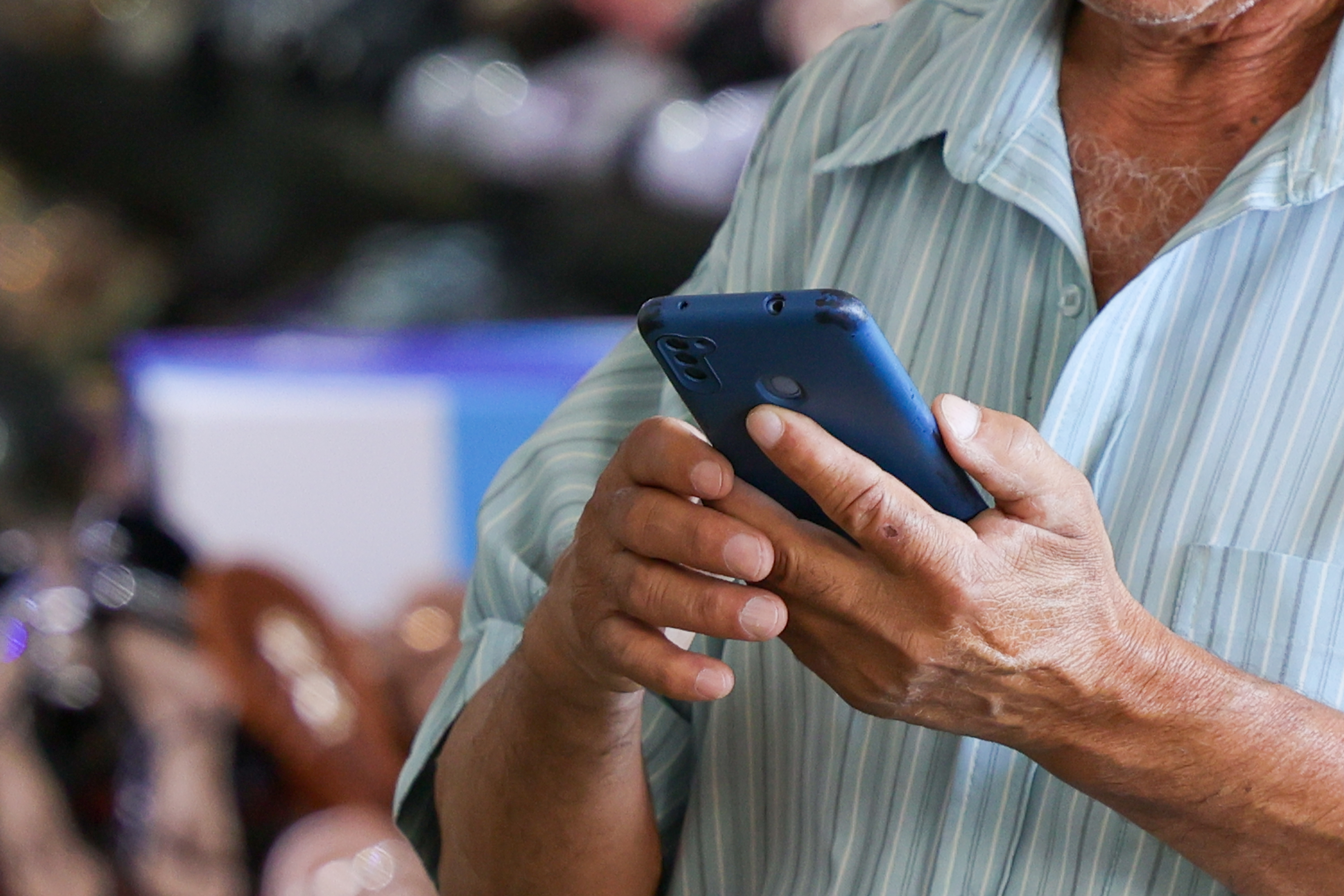 Homem idoso olhando a tela de um celular