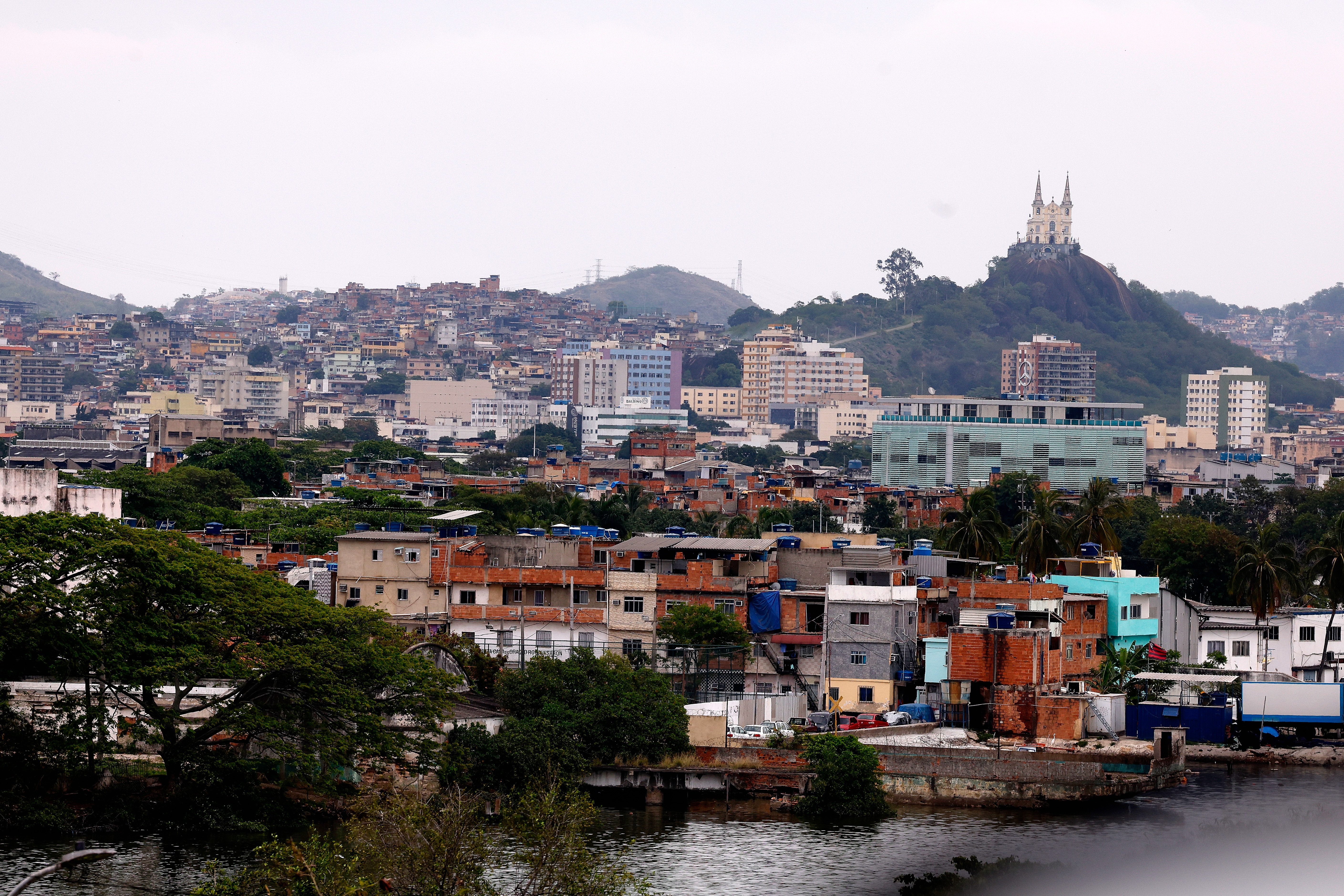 Vista da Igreja da Penha no alto do morro, com casas do Complexo da Penha ao redor, na Zona Norte do Rio