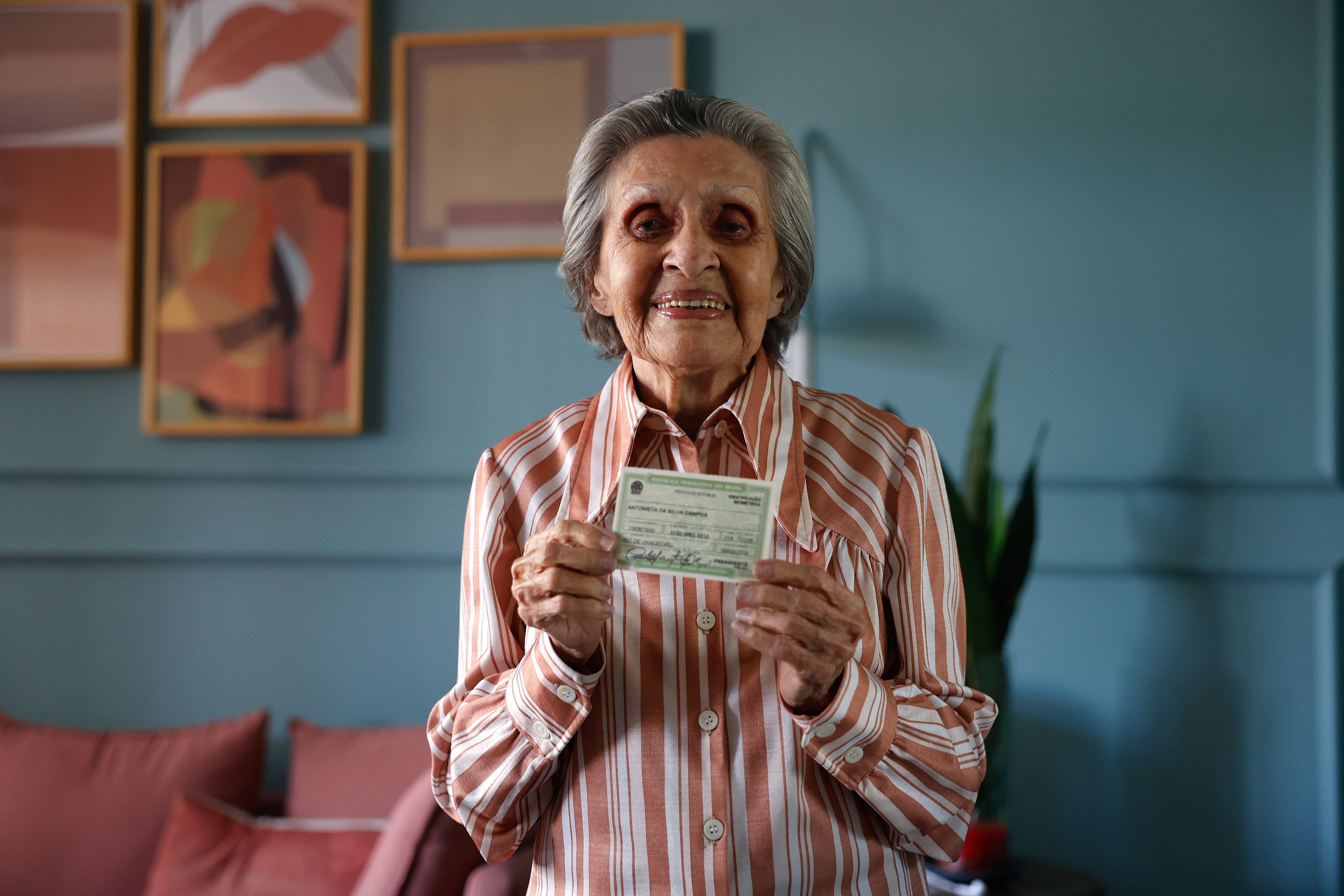 Eleitora exibe título de eleitor em sua casa, no Rio de Janeiro